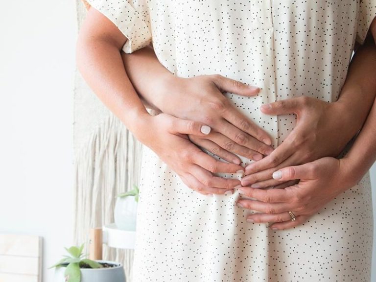 Mains sur le ventre d'une femme enceinte