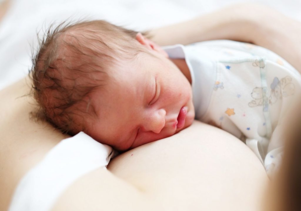 Nouveau-né tenu dormant sur le ventre de sa mère